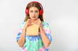 © Pixel-Shot - Surprised young woman listening to audiobook on light background