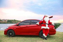 Santa Claus With Fir Tree In Car Trunk On Riverside