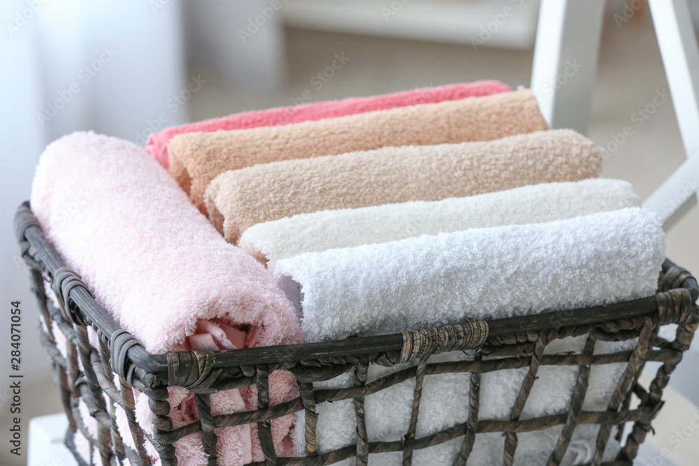 Basket with clean soft towels on chair in bathroom, closeup
