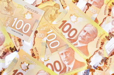 Canadian $100 dollar banknotes. The notes are dominantly brown in colour