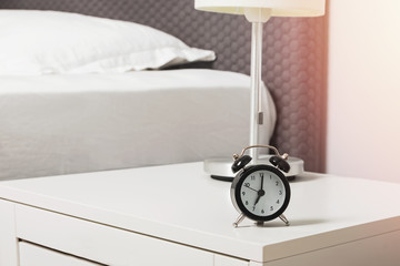 Wall Mural - Alarm clock standing on the nightstand near the bed