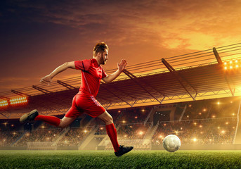 Wall Mural - Professional soccer player in action on a soccer stadium. Soccer championship. Dramatic night sky