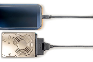 hdd 2.5 hard drive disk connected to smartphone via sata usb cable closeup overhead view