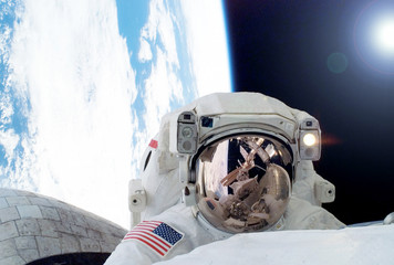 Wall Mural - astronaut in outer space at the station. against the background of the earth and the sun. elements o