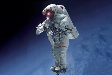 Wall Mural - an astronaut in outer space, stands on a platform that holds his legs. elements of this image were f