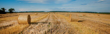 Yellow Golden Straw Bales Of Hay In The Stubble Field, Agricultural Field Under A Blue Sky With Clouds. Straw On The Meadow. Countryside Natural Landscape. Grain Crop, Harvesting.