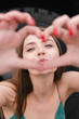 © Bohdan Melnyk - Young woman showing heart gesture with hands