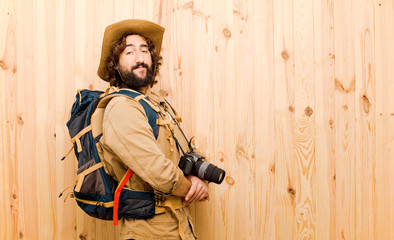 young crazy explorer with straw hat and backpack on wood backgro