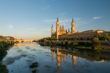 View of the cathedral of El Pilar de Zaragoza, next to the river Ebro, at sunset.