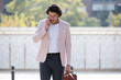 © guille Faingold/Stocksy - Proud young businessman talking with mobile phone in the street.