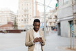 © Javier Pardina/Stocksy - African man speaking by phone at street