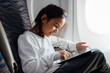 © Marko/Stocksy - Kid playing on tablet in airplane