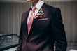 the groom in a suit and tie with a boutonniere