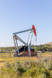 Small oil/gas pumpjack in the field. Alberta, Canada.