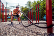 © zamuruev - Athletic looking man working out with rope at street gym yard. Strength and motivation. Outdoor workout.
