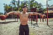 © zamuruev - Athletic man working out with a kettlebell at street gym yard. Strength and motivation. Outdoor workout.
