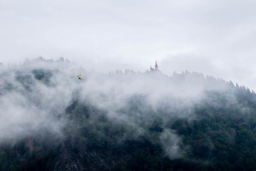  Mysterious view of forest on the mountain, castle and deltaplan in the thick fog