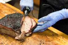 Barbecued And Smoked Brisket Being Cut And Served On Wooden Board