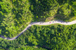 Aerial view of countryside road passing through the tropical rainforest and mountain in SouthEast Asia.