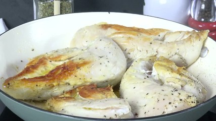 Sticker - Boneless chicken breasts cooking in a cast iron skillet