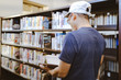 © Shubby Studio - Asian men wearing hats looking for books in the library
