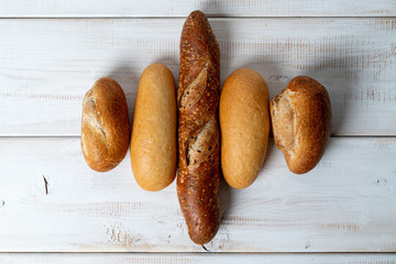 different mini baguettes on white wooden table