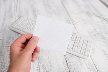 Wall Mural - man holding colorful reminder square shaped paper white keyboard wood floor