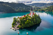 Bled, Slovenia - Beautiful morning at Lake Bled (Blejsko Jezero) with the Pilgrimage Church of the Assumption of Maria and traditional Pletna boats on the water on a bright summer day