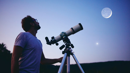 Wall Mural - astronomer with a telescope watching at the stars and moon. my astronomy work.