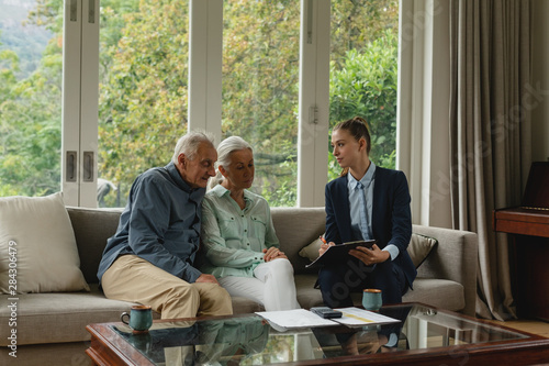 Cuadros en Lienzo Active senior couple discussing with real estate agent over documents in living