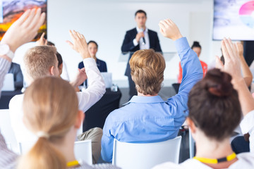 Wall Mural - Audience raising their hands in a business conference 