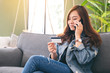 An asian woman using credit card for purchasing and shopping online while talking on mobile phone
