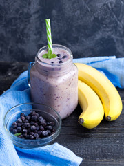 Wall Mural - A jar of dark smoothie with blueberries and banana on a wooden table