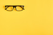 © Sviatoslav Kovtun - Black glasses on yellow background composition, eyeglasses.