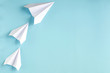 White paper planes on blue background composition.