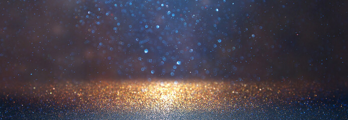 blackground of abstract glitter lights. blue, gold and black. de focused. banner