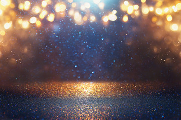 blackground of abstract glitter lights. blue, gold and black. de focused