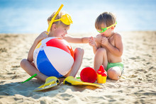 Pretty Cute Children On The Beach Having Fun. Smiling Kids In The Summer Time. Boys Outdoors.