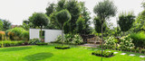 Fototapeta Tulipany - Piękny ogród z drewnianą ławką