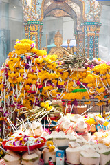 Sticker - Bangkok, Thailand - Offerings of incense, flowers and boxes are left at a Buddhist statue.