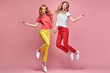 © evgenij918 - Fashion. Two Inspired woman laughing dance. Shapely joyful friend Having Fun, Stylish fashionable summer outfit. Carefree Girl friends with curly hair jump dancing in Studio, happy positive emotion