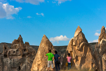 Poster - Tourists watching houses carved into the rock formations in the valley, Goreme, Cappadocia, Turkey (UNESCO World Heritage Site)