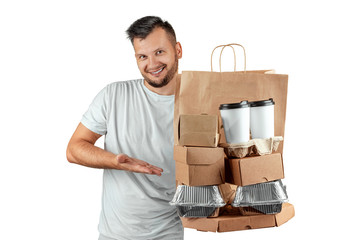 Man in a bright T-shirt giving a fast food order isolated on a white background. Male courier worker is holding food. Home delivery of goods from a store or restaurant. Copy space