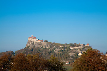 Poster - Austria - Low angle view of a village built on a mountaintop. Horizontal shot