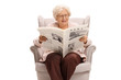 © Ljupco Smokovski - Senior lady sitting in an armchair and reading a newspaper