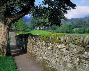 Sticker - England, Grasmere. A gray, stone wall is contrasted by the verdant fields near Grasmere, Lake District National Park, England.