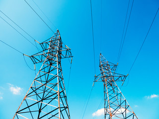 Two power towers against the blue sky on sunny day.