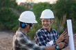 © SVRSLYIMAGES - portrait of two engineer's or architect's with hardhat walking across the field