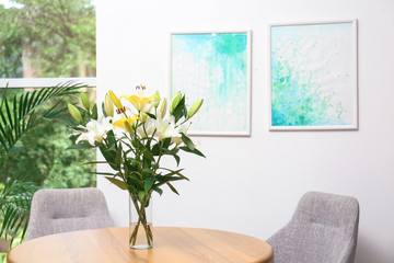 Canvas Print - Vase with bouquet of beautiful lilies on wooden table indoors. Space for text