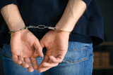 Fototapeta  - Man detained in handcuffs indoors, closeup view. Criminal law